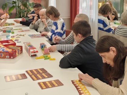 Na zdjęciu grupa mieszkańców wraz z młodzieżą gra w gry towarzyskie.