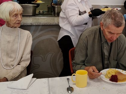 starsze osoby spożywające posiłek przy świątecznym stole