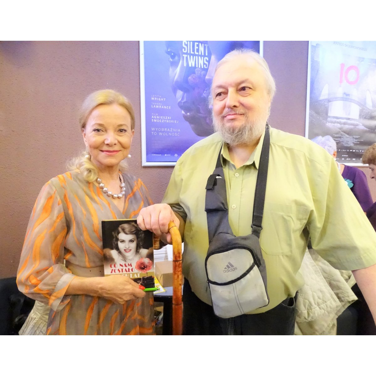 Aktorka Laura Łącz trzyma swoją książkę obok mieszkańca o lasce