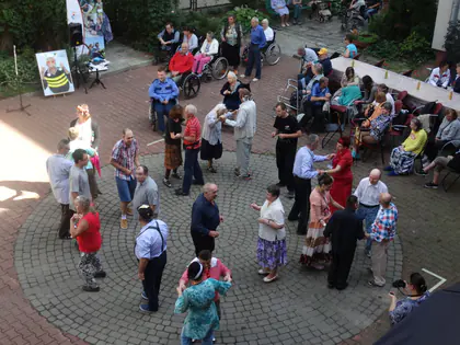 Widok z góry na tańczące pary i gości siedzących wokół na podwórku podczas pikniku
