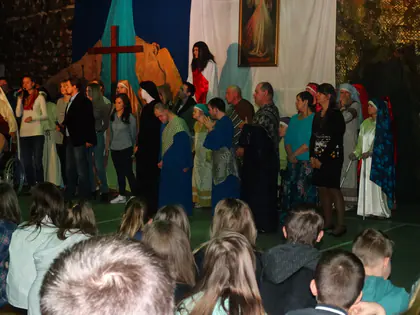 Aktorzy w strojach biblijnych i goście stoją na scenie, młodzież siedzi na podłodze