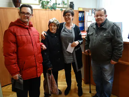 Czworo mieszkańców w zimowych kurtkach pozuje w biurze przed wyjściem