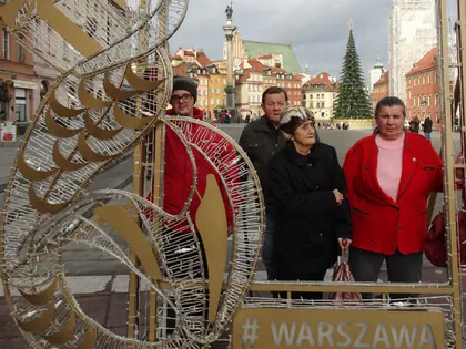 Mieszkańcy pozują w świetlnej ramie „#Warszawa” na placu Zamkowym
