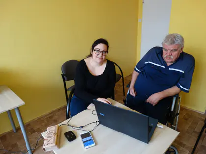 Kobieta i starszy mężczyzna siedzą przy laptopie podczas zajęć komputerowych