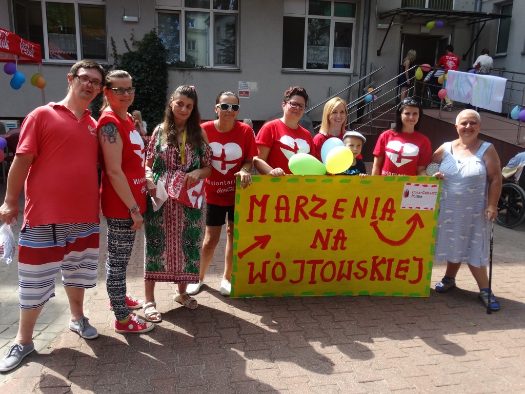 Wolontariusze i mieszkańcy z transparentem „Marzenia na Wójtowskiej” przed wejściem do Domu.