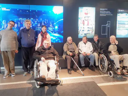 Mieszkańcy z opiekunami przed ekranem w Centrum Nauki Kopernik