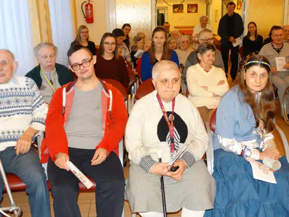 Mieszkańcy siedzą w pierwszym rzędzie, za nimi dzieci i opiekunowie