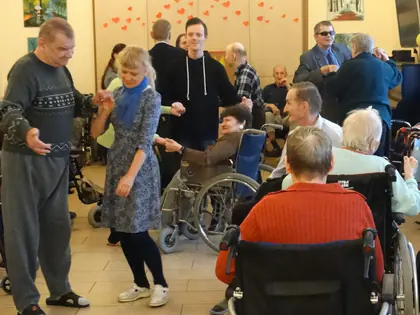 Mieszkańcy i goście tańczą w świetlicy ozdobionej sercami