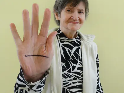 Mieszkanka pokazuje dłoń z narysowaną czarną poziomą linią