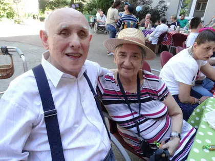 Mieszkaniec i mieszkanka w kapeluszu podczas pikniku pod kasztanami