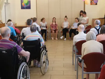 Dzieci prezentują przedstawienie o Janie Pawle II przed mieszkańcami w świetlicy