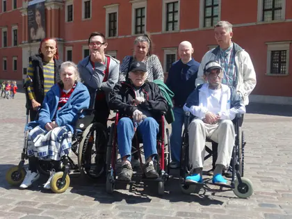 Mieszkańcy na wózkach z opiekunami na placu przed Zamkiem Królewskim