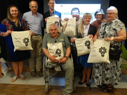 Seniorzy z torbami budżetu partycypacyjnego podczas podsumowania projektów