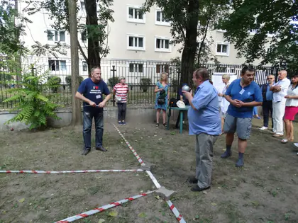 Seniorzy biorą udział w zawodach na trawniku wydzielonym taśmą
