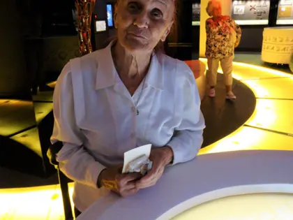 Starsza mieszkanka przy podświetlanym stole w muzeum