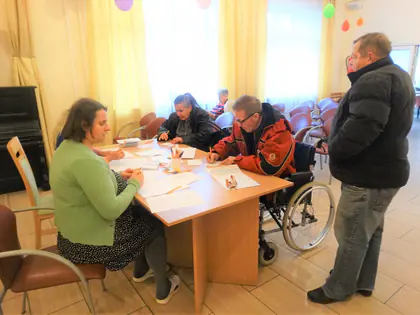 Mieszkańcy przy stole piszą listy do świętego Mikołaja