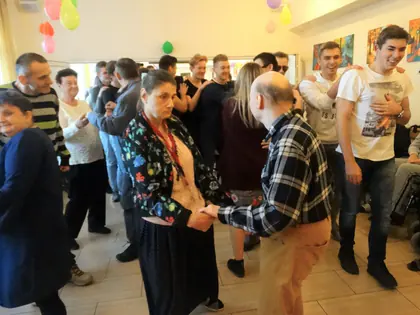 Mieszkańcy i goście tańczą na balu andrzejkowym w sali z balonami