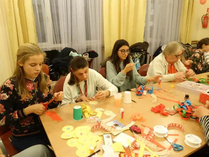 Dziewczęta i mieszkanki wykonują ozdoby świąteczne przy stole
