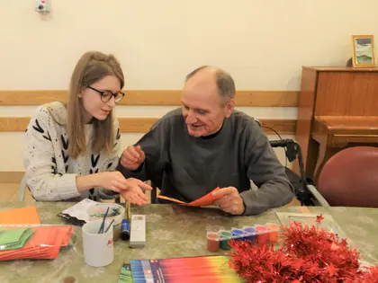 Mieszkaniec i studentka robią ozdoby z kolorowego papieru