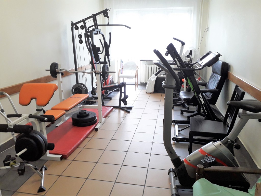 Druga sala terapii ruchowej: rowerki, bieżnia i urządzenia do ćwiczeń siłowych.