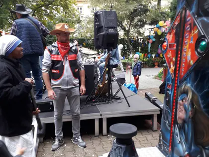 Mieszkańcy i muzyk w stroju kowbojskim przy dekoracji na podwórku