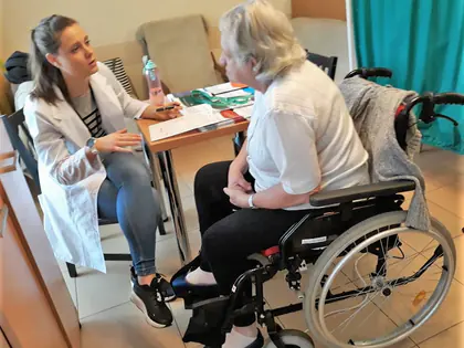 Pielęgniarka rozmawia z mieszkanką na wózku