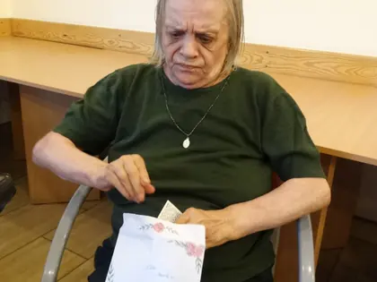 Mieszkanka otwiera kopertę z listem