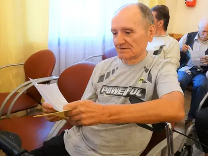Mieszkaniec czyta list siedząc w świetlicy