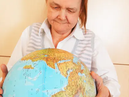 Mieszkanka trzyma duży globus w dłoniach