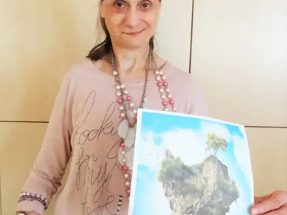 Mieszkanka pokazuje plakat z wyspą w kształcie serca
