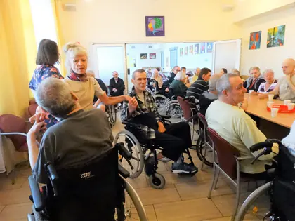 Mieszkańcy przy stołach w świetlicy podczas biesiady kończącej projekt