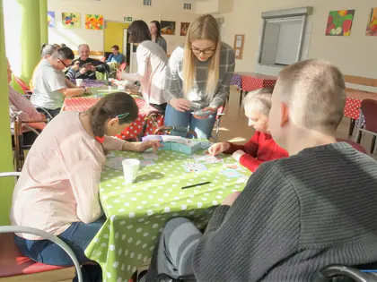 Wolontariuszki grają w gry planszowe z mieszkańcami przy stołach