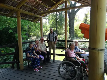 Mieszkańcy odpoczywają w drewnianej wiacie w zoo