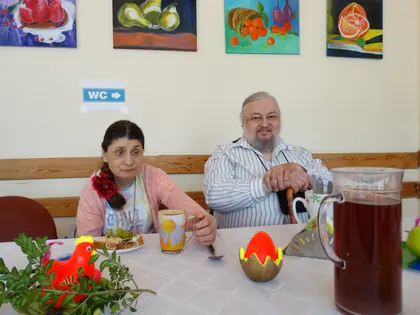 Mieszkanka i mieszkaniec przy stole z wielkanocnymi ozdobami
