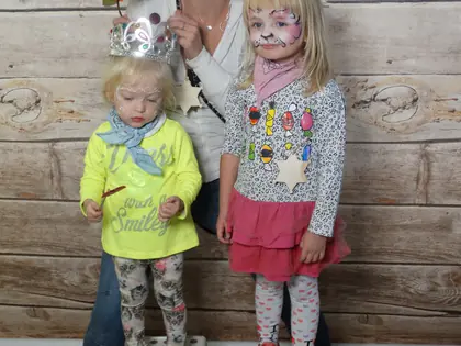 Kobieta z pomalowaną twarzą i dwie dziewczynki pozują do zdjęcia