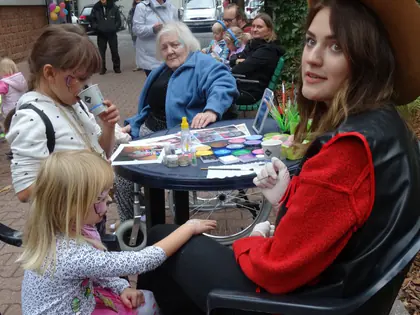 Malarka twarzy w kowbojskim kapeluszu i dzieci przy stoliku