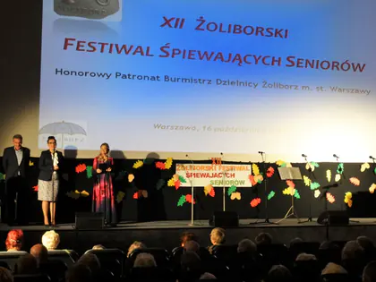 Scena XII Żoliborskiego Festiwalu Śpiewających Seniorów z prowadzącymi