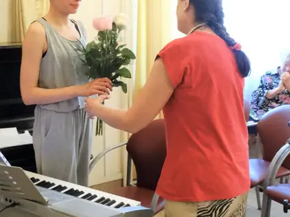 Pianistka w turbanie otrzymuje bukiet róż od opiekunki