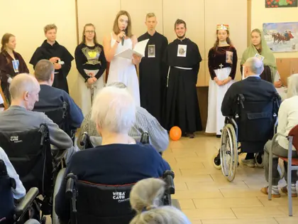 Młodzież przebrana za świętych prezentuje widowisko przed mieszkańcami