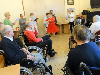 Seniorzy z grupy teatralnej odgrywają przedstawienie przed mieszkańcami w świetlicy
