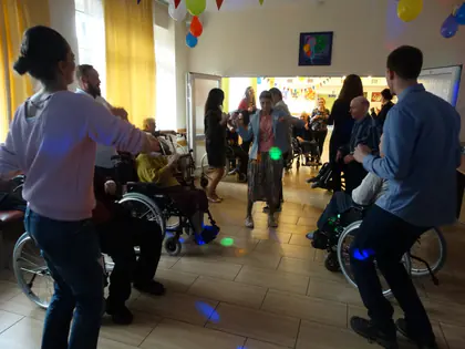 Mieszkańcy i goście tańczą na andrzejkowym balu w sali z balonami