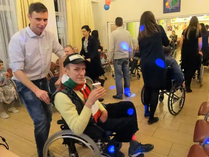 Młody mężczyzna i mieszkaniec na wózku z kubkiem podczas zabawy andrzejkowej