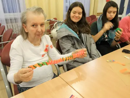 Mieszkanka i dziewczęta pokazują łańcuch z papieru przy stole