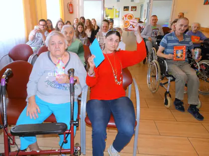 Mieszkanki z prezentami od młodzieży unoszą je do góry