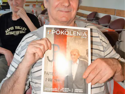 Uśmiechnięty mieszkaniec pokazuje okładkę magazynu Pokolenia
