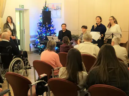 Młodzi wokaliści występują przy choince przed mieszkańcami
