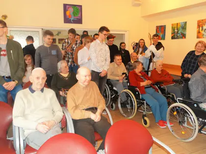 Młodzież i mieszkańcy pozują w świetlicy po jasełkach