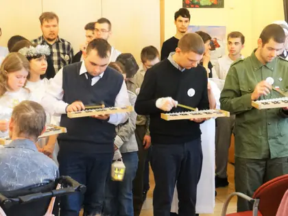 Młodzież gra na drewnianych cymbałkach wśród mieszkańców