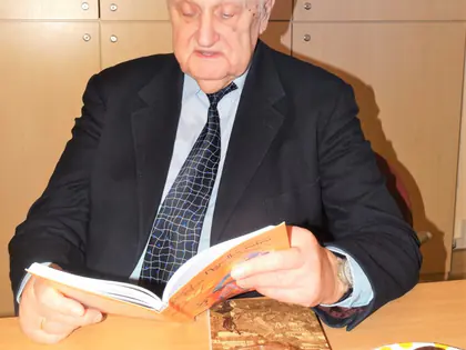 Starszy mężczyzna w garniturze czyta z książki