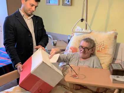 Mieszkanka leżąca w łóżku głosuje do przenośnej urny